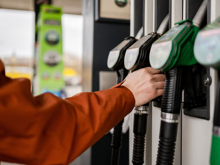 Man Grabbing A Fuel Pump At A Gas Station Refueling A Car